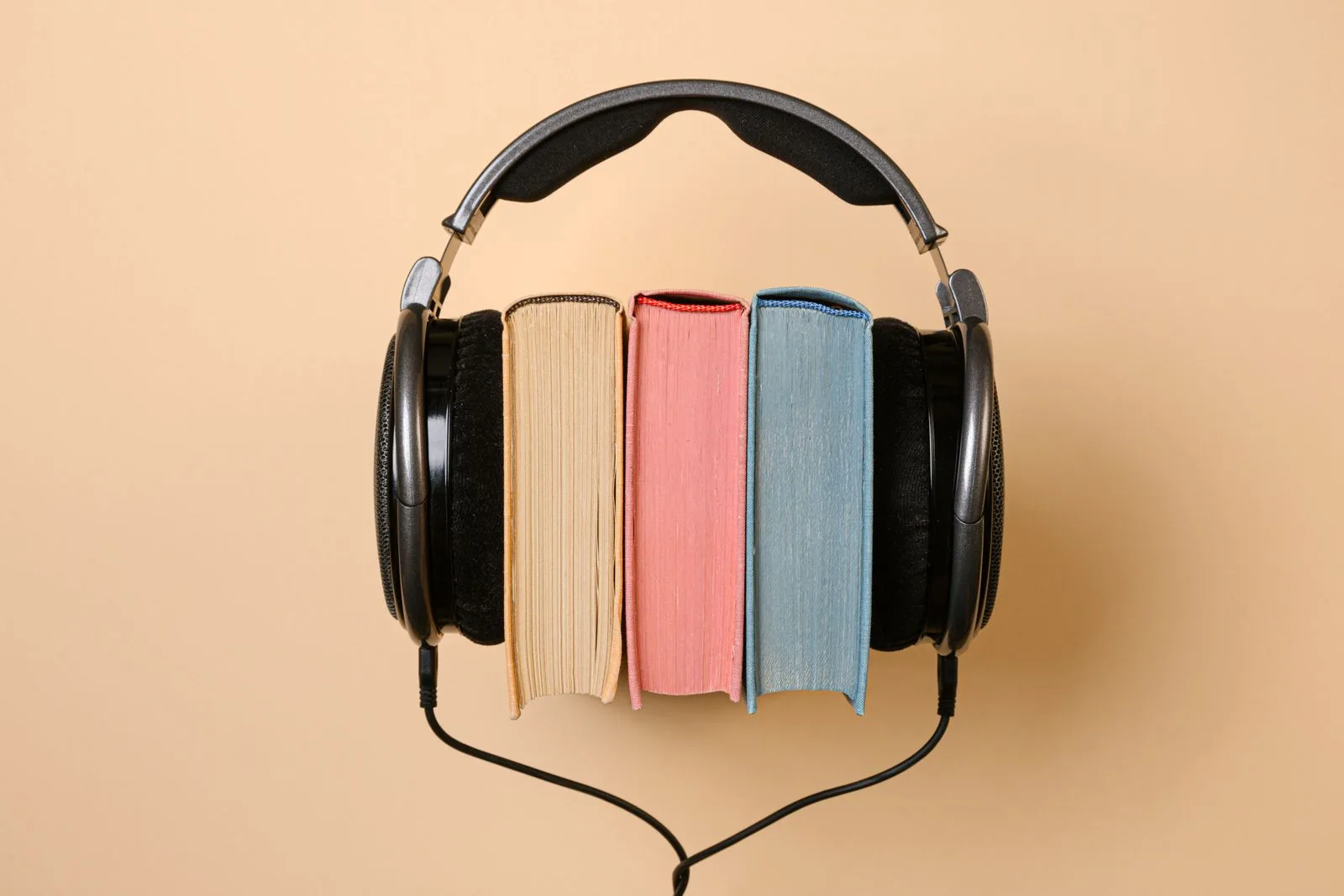 Three little books tucked inside a pair of headphones